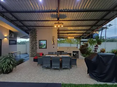 a patio with a table and chairs in a building at Villa Graceland - Arenal Volcano View in Fortuna