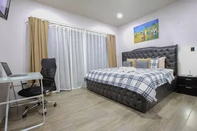 a bedroom with a bed and a desk and a computer at Villa Graceland - Arenal Volcano View in Fortuna