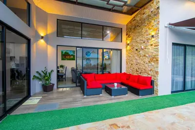 a living room with a red couch and a brick wall at Villa Graceland - Arenal Volcano View in Fortuna