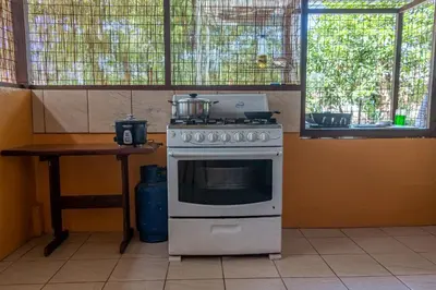 a stove with a pot on top of it in a kitchen at Hacienda el Paraíso in Guápiles