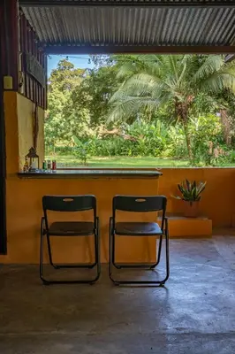 two chairs sitting next to a counter with a window at Hacienda el Paraíso in Guápiles