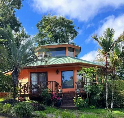a small orange house with a green roof at Beautiful 3BR Lakeshore House in Gated Community in Tilarán
