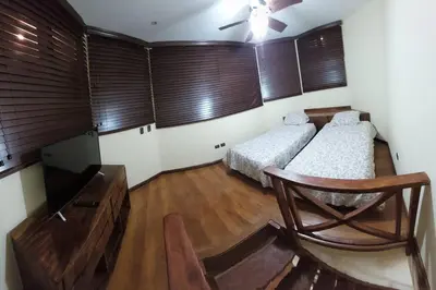 a bedroom with two beds and a flat screen tv at Beautiful 3BR Lakeshore House in Gated Community in Tilarán