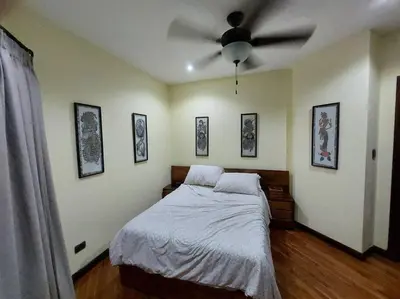 a bedroom with a bed with a ceiling fan at Beautiful 3BR Lakeshore House in Gated Community in Tilarán