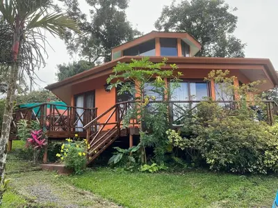 a small house with a balcony in the yard at Beautiful 3BR Lakeshore House in Gated Community in Tilarán