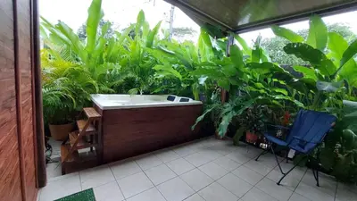 a bath tub in a garden with plants at White Passiflora - Private Jacuzzi in Fortuna