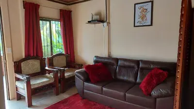 a living room with a leather couch and a mirror at White Passiflora - Private Jacuzzi in Fortuna
