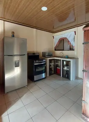 a kitchen with a stainless steel refrigerator and a tile floor at White Passiflora - Private Jacuzzi in Fortuna