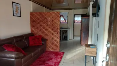a living room with a brown couch and a table at White Passiflora - Private Jacuzzi in Fortuna