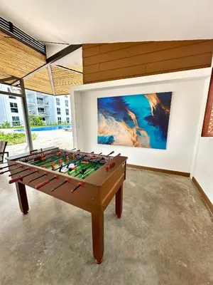 a ping pong table in a room with a painting at Viva in Jacó