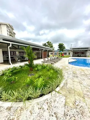 a resort with a pool and chairs and a building at Viva in Jacó