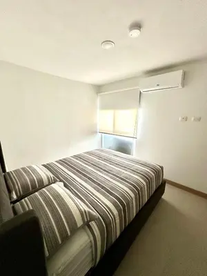 a bedroom with a bed in a room with a window at Viva in Jacó