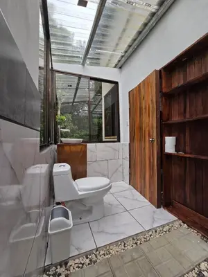 a bathroom with a toilet and a sink at Happy Paradise Lodge in Nuevo Arenal