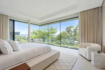 a bedroom with a large bed and a large window at Luxurious Villa in Papagayo in Nacascolo