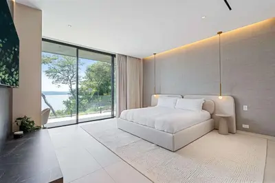 a bedroom with a white bed and a large window at Luxurious Villa in Papagayo in Nacascolo