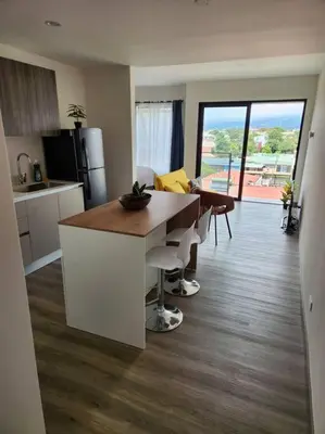 a kitchen and living room with a table and chairs at Mountain View Estudio in Cinco Esquinas