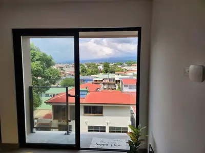 a window in a room with a view of a building at Mountain View Estudio in Cinco Esquinas