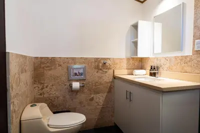a bathroom with a toilet and a sink at Ocean Apartments- Walk to the beach in Santa Teresa Beach