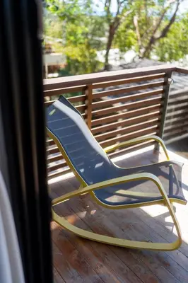 a blue chair sitting on a deck next to a bench at Ocean Apartments- Walk to the beach in Santa Teresa Beach