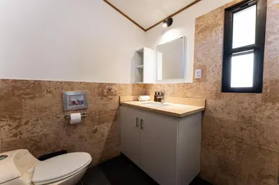 a bathroom with a toilet and a sink at Ocean Apartments- Walk to the beach in Santa Teresa Beach