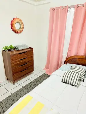 a bedroom with a bed and a dresser with pink curtains at Sweet Home Carrion 2 y 3 in Fortuna