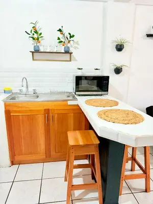a kitchen with a sink and a counter with two stools at Sweet Home Carrion 2 y 3 in Fortuna