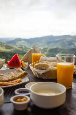 a table topped with plates of food and glasses of orange juice at Nosara Hideaway 2 - BREAKFAST PROVIDED & Mountain View Cabins in Nicoya