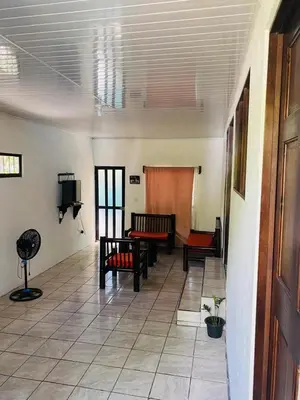 a living room with benches and a tv in a room at Cabinas chinchilla dos in Quepos
