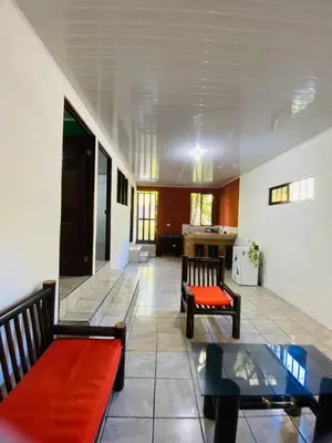 a living room with two benches and a table at Cabinas chinchilla dos in Quepos