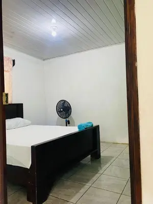 a bedroom with a bed and a clock on the wall at Cabinas chinchilla dos in Quepos