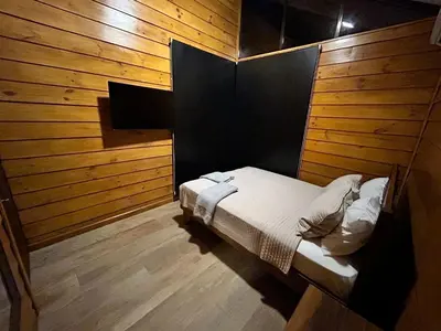 a bedroom with a bed in a wooden wall at Eco Casa Mango Lepanto #10 in Lepanto