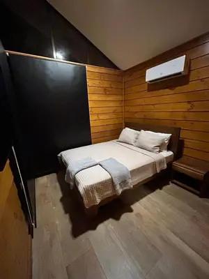a small bedroom with a bed with a wooden wall at Eco Casa Mango Lepanto #10 in Lepanto