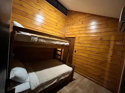 a room with two bunk beds in a wooden wall at Eco Casa Mango Lepanto #10 in Lepanto