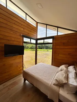 a bedroom with a bed and a large window at Eco Casa Mango Lepanto #10 in Lepanto
