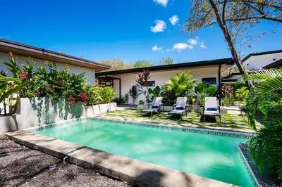 a swimming pool in front of a house at Villa Serenity 2 Bedroom 1 min walk to the beach in Santa Cruz