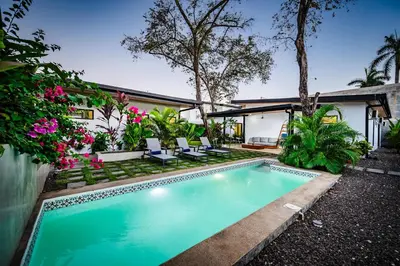 a swimming pool in front of a house at Villa Serenity 2 Bedroom 1 min walk to the beach in Santa Cruz