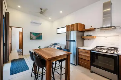 a kitchen with a wooden table and a stove at Villa Serenity 2 Bedroom 1 min walk to the beach in Santa Cruz