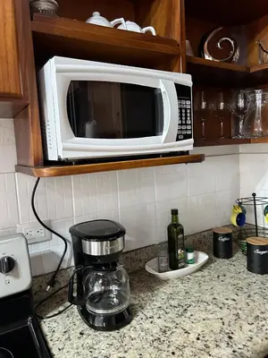 a microwave on top of a kitchen counter at SJO airport 4 min free parking in Alajuela City