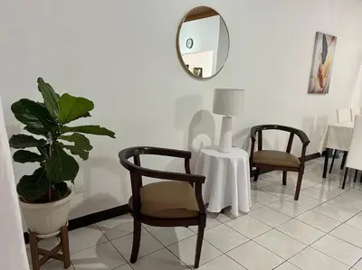 a room with two chairs and a table and a mirror at SJO airport 4 min free parking in Alajuela City