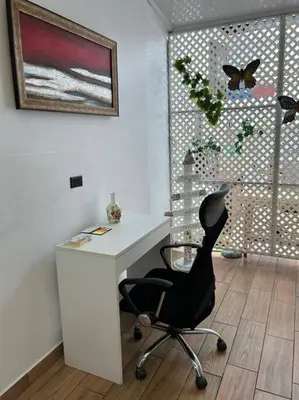 a white desk with a black chair in a room at SJO airport 4 min free parking in Alajuela City