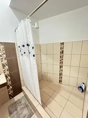 a shower with a shower curtain in a bathroom at SJO airport 4 min free parking in Alajuela City