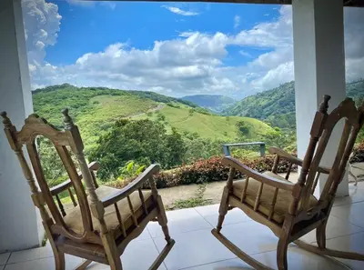 two chairs sitting in front of a window with a view at Alas House, Monteverde with amazing sunset view! in Monteverde Costa Rica