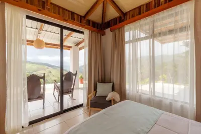 a bedroom with a bed and a large window at Alas House, Monteverde with amazing sunset view! in Monteverde Costa Rica