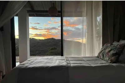 a bed in front of a window with a view at Alas House, Monteverde with amazing sunset view! in Monteverde Costa Rica