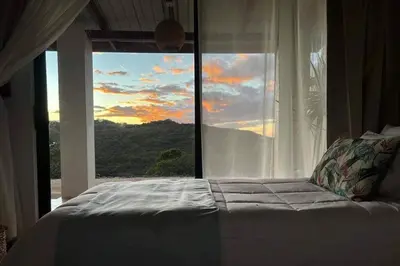 a bedroom with a bed and a large window at Alas House, Monteverde with amazing sunset view! in Monteverde Costa Rica