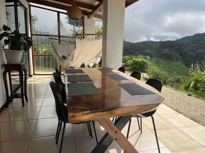 a wooden table and chairs in a room with a view at Alas House, Monteverde with amazing sunset view! in Monteverde Costa Rica