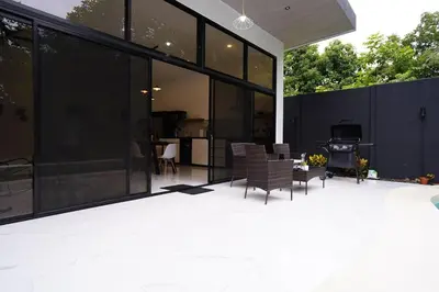 a patio with black windows and chairs on it at Private Paradise between Beach and Jungle in Uvita in Uvita
