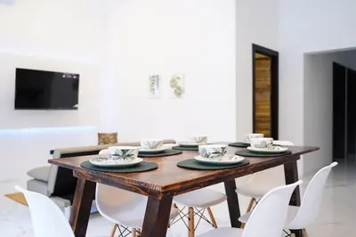 a dining room with a wooden table and white chairs at Private Paradise between Beach and Jungle in Uvita in Uvita