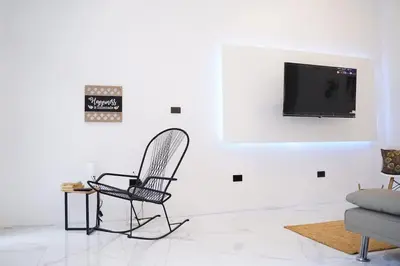 a living room with a chair and a tv on a wall at Private Paradise between Beach and Jungle in Uvita in Uvita