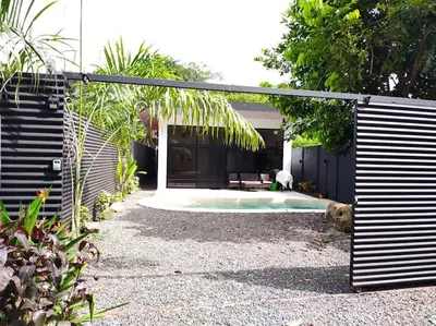 a backyard with a pool with a dog sitting next to it at Private Paradise between Beach and Jungle in Uvita in Uvita